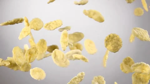 Cereal corn flakes are flying on the white background in the slow motion Stock Footage 302437303