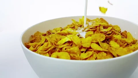Cereal corn flakes falling down in a bowl pouring with milk,  slow motion Video stock 79155465