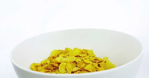 Cereal corn flakes falling down in a bowl on white background, concept of diet Video stock 79217648