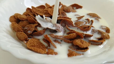 Cereal flakes against white background milk flies Stock Footage 87945454