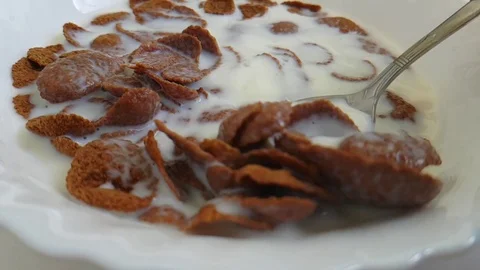 Cereal flakes against white background milk flying Stock Footage 87945471