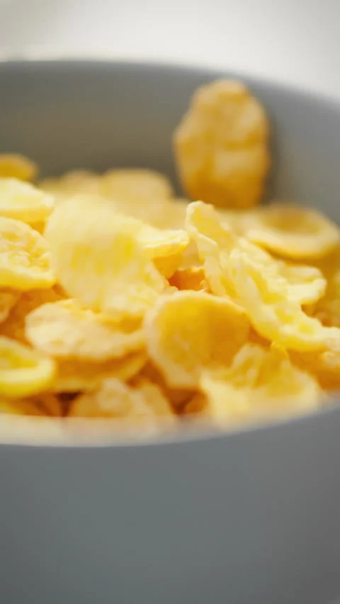 Cereal flakes gracefully cascade into a bowl in a slow motion display of bre Stock Footage 331536532