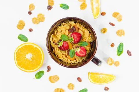 Cereal, morning breakfast, corn flakes, raisins, almonds, mint leaves, orange Stock Photos