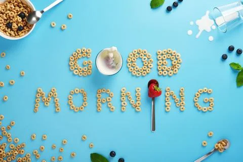 Cereal rings forms the phrase good morning on a blue background with berries, Foto stock