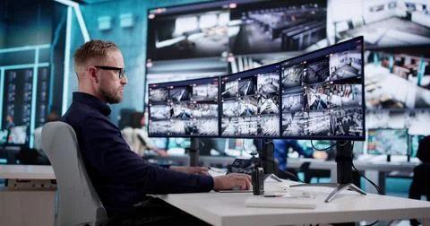 Certified CCTV Technician Monitors Multiple Screens In Security Surveillance  Foto stock