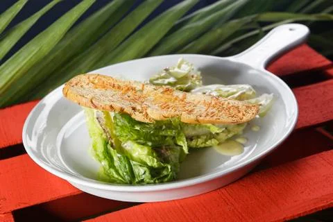 Cesar salad with lemon dressing, walnuts and cheese-toasted bread. Stock Photos