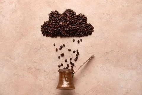 Cezve with cloud made of coffee beans on beige grunge background Stock Photos