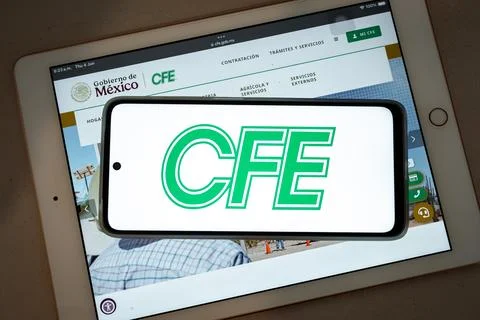 Cfe logo on smartphone screen over tablet Fotos de archivo