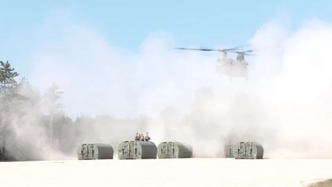 CH-47 Chinook creating dust storm during pontoon bridge sling load operations Video stock 289628586