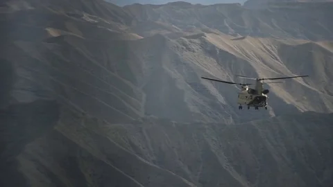 CH-47 Chinook flies between mountains of Afghanistan Видео 87319191