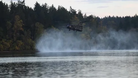 CH-47 Chinook generating prop wash as it approaches a lake Stock Footage 289079100