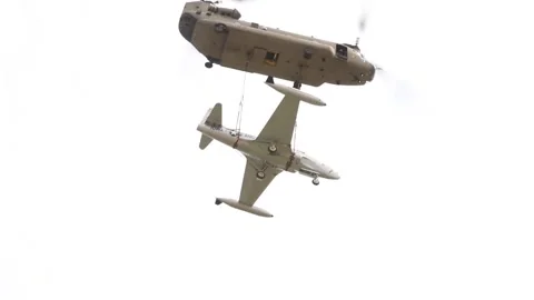CH-47 Chinook helicopter transporting F-80 'Shooting Star' aircraft by sling Stock Footage 211806367