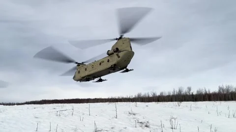 CH-47 Chinook taking off from snow-covered landscape with snow skis fitted Stock Footage 295350190