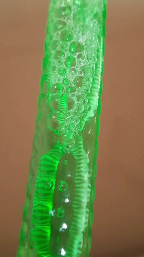 Chain of Air Bubbles Moving Down and Connecting in Green Tube 库存影片 344395964