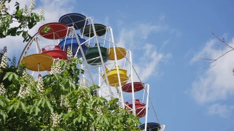 The chain carousel rotates in the amusement park. Colorful seats against a blue Stock Footage 241019967