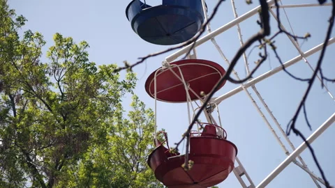 The chain carousel rotates in the amusement park. Colorful seats against a blue Stock Footage 242516970