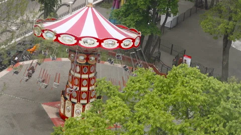 Chain carousel rotating in circle among trees in amusement park, top view. Stock Footage 334381956