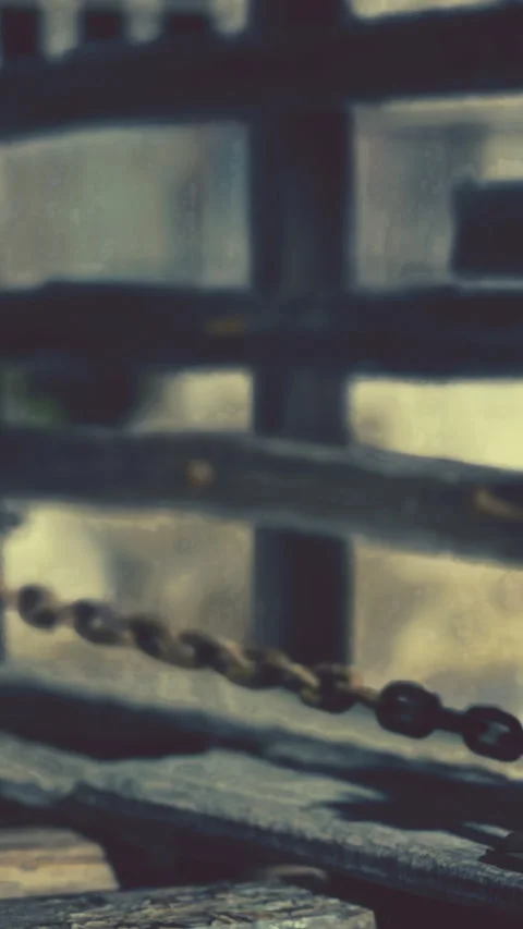 Chain connected to a post in a weathered outdoor setting at daytime Stock Footage 338000071