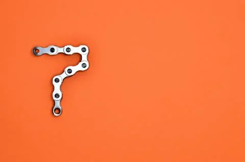 Chain forms number seven on a bright orange paper 스톡 사진