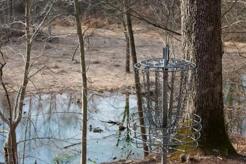 A Chain Frisbee Golf Hole in a Winter Forest With a Pond in the Background Stock Photos