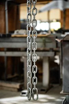 A chain hangs from the ceiling in a workshop Stock Photos