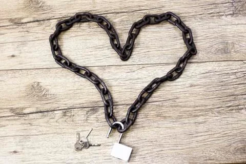 Chain heart shape with open lock on wooden backround Stock Photos