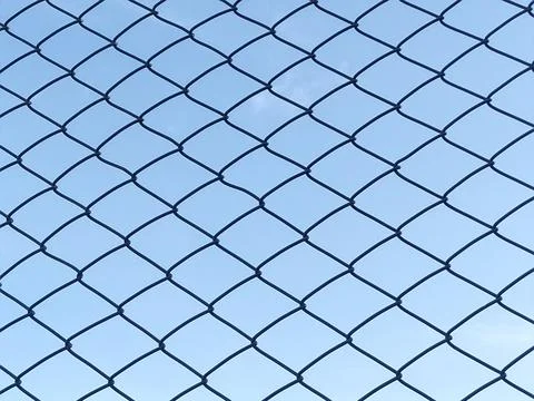 Chain Link Fence Pattern Against Blue Sky_01 Stock Photos