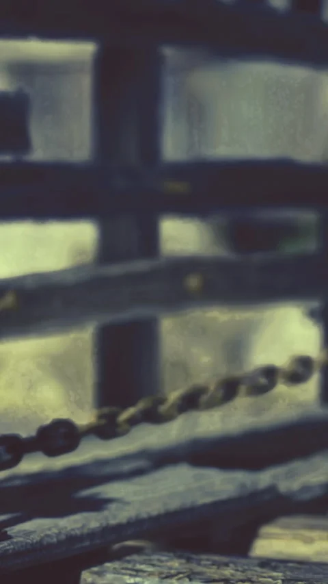 Chain links connected to wooden structure in a workshop setting Stock Footage 331369190