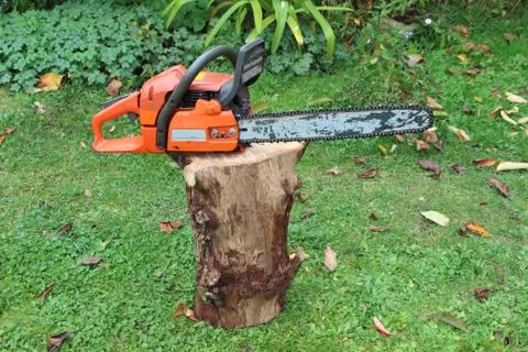 Chain saw on a log Stock Photos