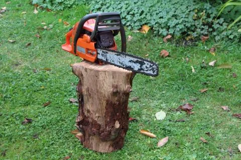 Chain saw on a log Stock Photos