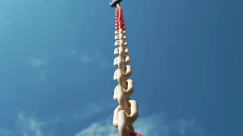 Chain Swinging. white-red chain against a blue sky. close-up. Chain links. red Stock Footage 258459079