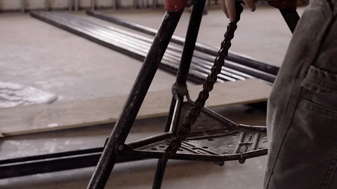 A Chain Swings Beneath A Power Tool On A Construction Site Stock Footage 87483073