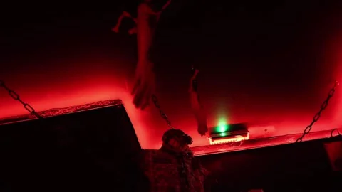 Chained horror figure in red light creates an intense nightmare atmosphere insid Vidéo 346305142