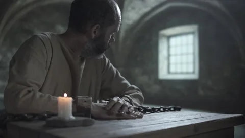 Chained man rubbing his hand, staring ahead and turning look to a window 스톡 동영상 339631264