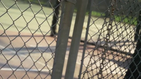 A chainlink fence closes at a recreational playground park batting cages, slow m Stock Footage