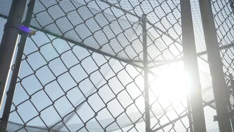 A chainlink fence closes at a recreational playground park batting cages, super Stock Footage