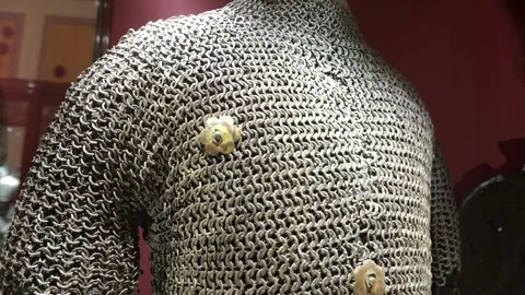 Chainmail hauberk close up brass rosette clasps steel rings palace armoury grand Stock Footage 341772559