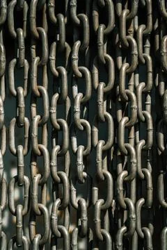 Chains background. Vertically hanging chains on a lawn background Stock Photos