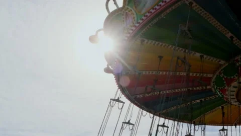 Chains from circular swing close-up in amusement park, sun shine in camera Stock Footage 231928589