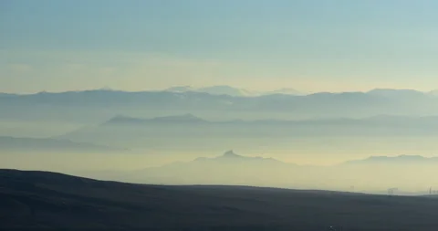 Chains of high mountain peaks and mountain valleys covered with thick morning Stock Footage 232299507