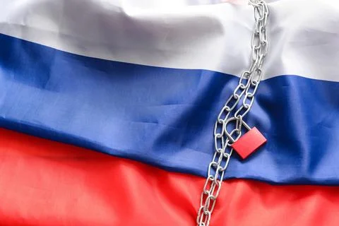 Chains with lock on flag of Russia. Sanctions concept Stock Photos