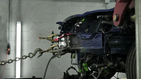 Chains Pull Out the Damaged Car Frame on a Straightening Rack Stock Footage 323529175