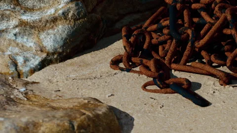 Chains on the sandy shore near rocks at the beach during daylight hours Stock Footage 344402983