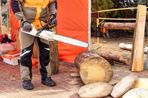 Chainsaw in action at a wood processing site under warm afternoon light Stock Photos