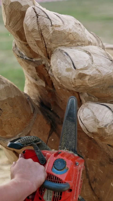 Chainsaw art creating handsome man. Wooden sculpture making. Vertical video Stock Footage 325040934
