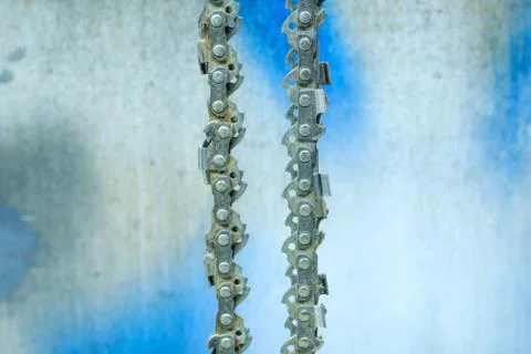 Chainsaw blade chain close-up on the background of the old wall in the garage Stock Photos