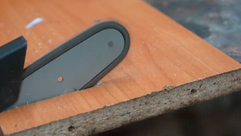 Chainsaw blade cutting through particleboard panel Video stock 327401874