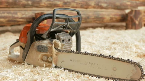 Chainsaw builder at the site of construction of a wooden house. Many sawdust and Stock Footage 69057498