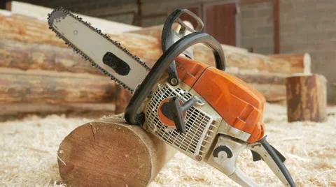 Chainsaw builder at the site of construction of a wooden house. Many sawdust and Stock Footage 69058629