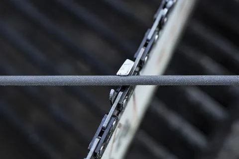 Chainsaw chain sharpening with a special round file, soft focus close up Stock Photos